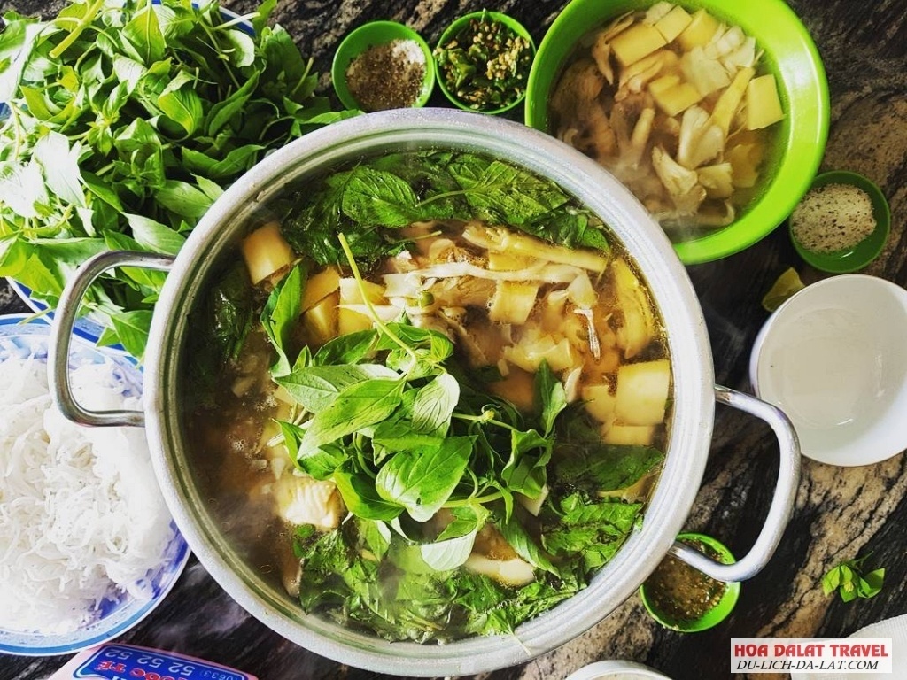 Nồi lẩu gà quán Hạnh với nước lẩu trong ăn kèm lẩu gà được bày trên đĩa